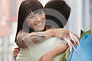 Young couple embracing with shopping bags, outdoors, Beijing