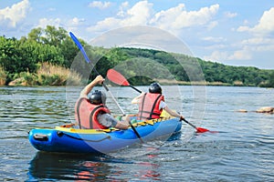 Young couple enjoy white water kayaking on the river