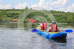 Young couple enjoy white water kayaking on the river