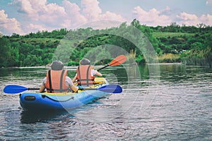 Young couple enjoy white water kayaking on the river