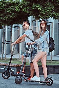 Young couple is enjoying electro scooter`s riding