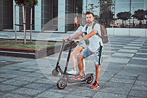 Young couple is enjoying electro scooter`s riding