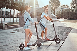 Young couple is enjoying electro scooter`s riding