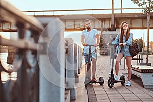 Young couple is enjoying electro scooter`s riding