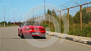 Young couple enjoying high speed ride in red convertible auto, carefree life