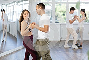 Young couple enjoying impassioned merengue in latin dance class