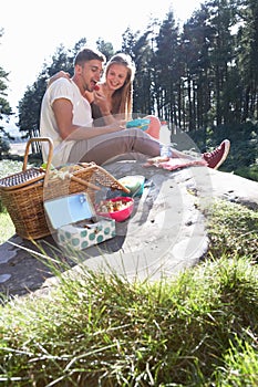 Young Couple Enjoying Picnic In Countryside