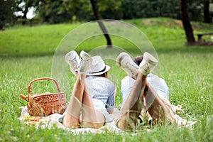 Young couple enjoying relaxing picnic time in a park, lying on a picnic blanket