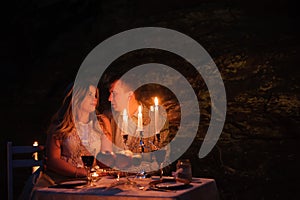Young couple enjoying a romantic dinner by candlelight, outdoor.