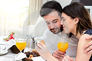 Young couple enjoying room service in suite.