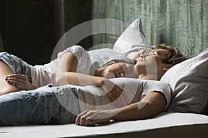 Young couple enjoying sleep on daytime lying in bed together