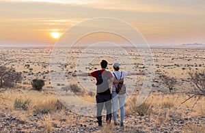 .Young couple enjoying the sunset in an African landscape.Young couple enjoying the sunset in an African landscape