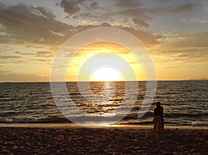 Young couple enjoying the sunset on the beach