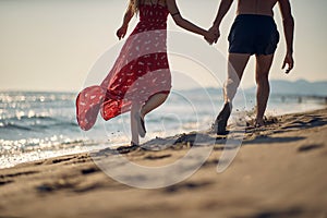 A young couple enjoying a walk on the beach. Summer, beach, sea, vacation