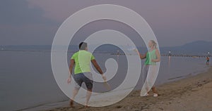 Young couple entertaining themselves with tennis on the beach