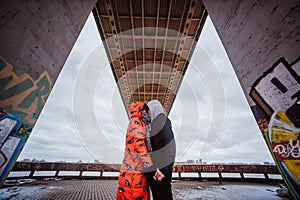 Young couple in the evening under the bridge