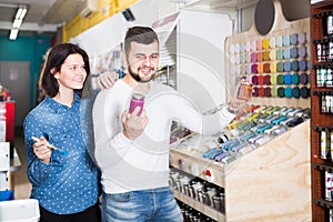 Young couple examining various paints in paint store