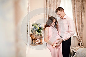 Young couple expecting baby standing together. Romantic moment for a pregnant couple. Planned Parenthood. Pregnancy, maternity,
