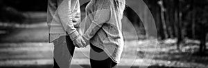 Young couple facing each other while holding hands, black and white, expressing love,