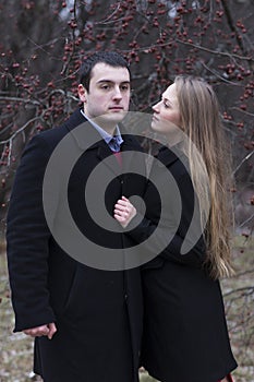 Young couple in falling park over the tree and berries background