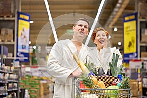 Young couple family emotionally react on discounts in grocery store, in bathrobe