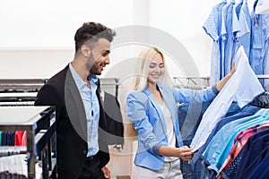 Young Couple Fashion Shop, Happy Smiling Man And Woman Customers Choosing Clothes Formal Wear Shopping