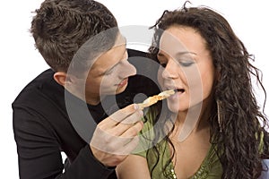 Young couple feeding each other roll cake