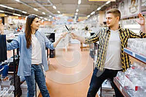 Young couple fencing in houseware store