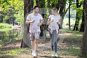 young couple fitness in sportswear running together in park . sport man and woman jogging outdoors in nature. workout ,exercising