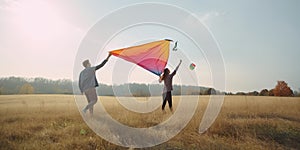 A young couple flying a colorful kite in an open field, capturing the whimsy and joy of engaging in outdoor activities