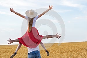 Young couple fooling around in a wheat field. Man and woman having fun in countryside