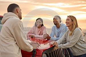 Young Couple With Friends Standing Chatting By Car At Beach Watching Sunrise Together photo