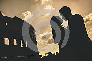 Young couple in front of the Colosseum in Rome at sunset