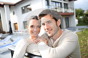 Young couple in front of their home