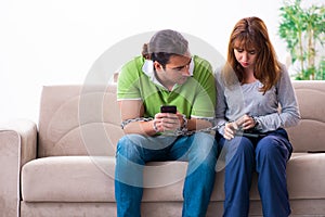 Young couple in gadget dependency concept