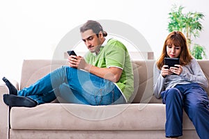 Young couple in gadget dependency concept