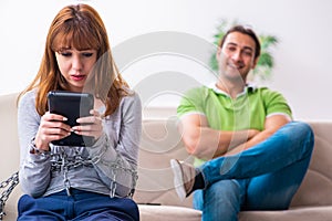 Young couple in gadget dependency concept