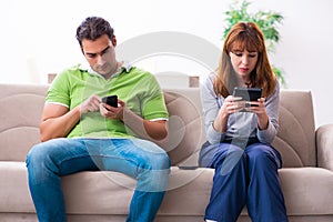 Young couple in gadget dependency concept