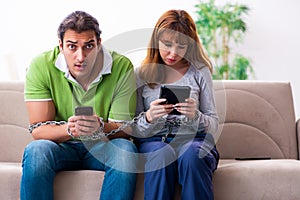 Young couple in gadget dependency concept