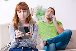 Young couple in gadget dependency concept