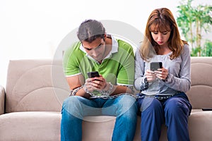 Young couple in gadget dependency concept