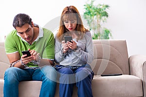 Young couple in gadget dependency concept
