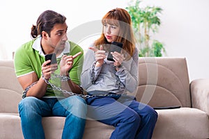 Young couple in gadget dependency concept