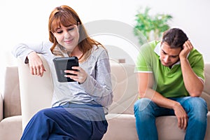 Young couple in gadget dependency concept