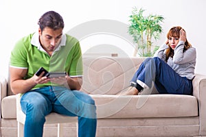 Young couple in gadget dependency concept