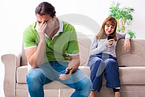 Young couple in gadget dependency concept