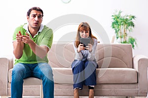 Young couple in gadget dependency concept