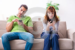 Young couple in gadget dependency concept