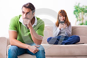 Young couple in gadget dependency concept