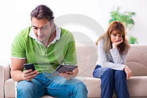 Young couple in gadget dependency concept